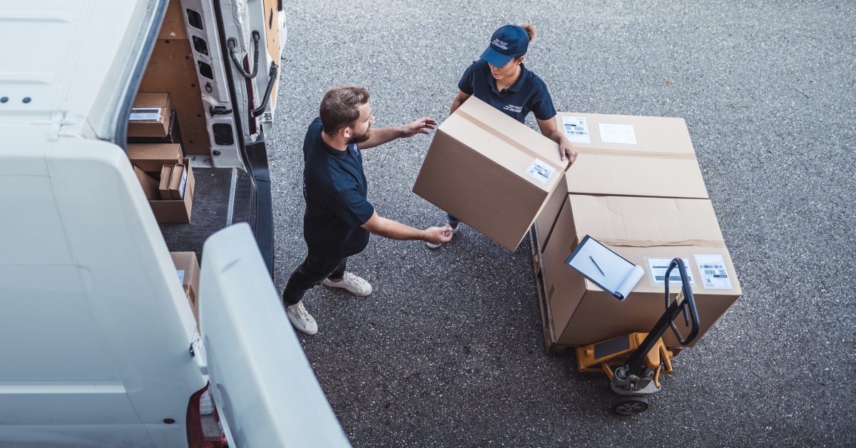 Delivery workers using a Hydraulic Hand Pallet Truck to load a delivery van.