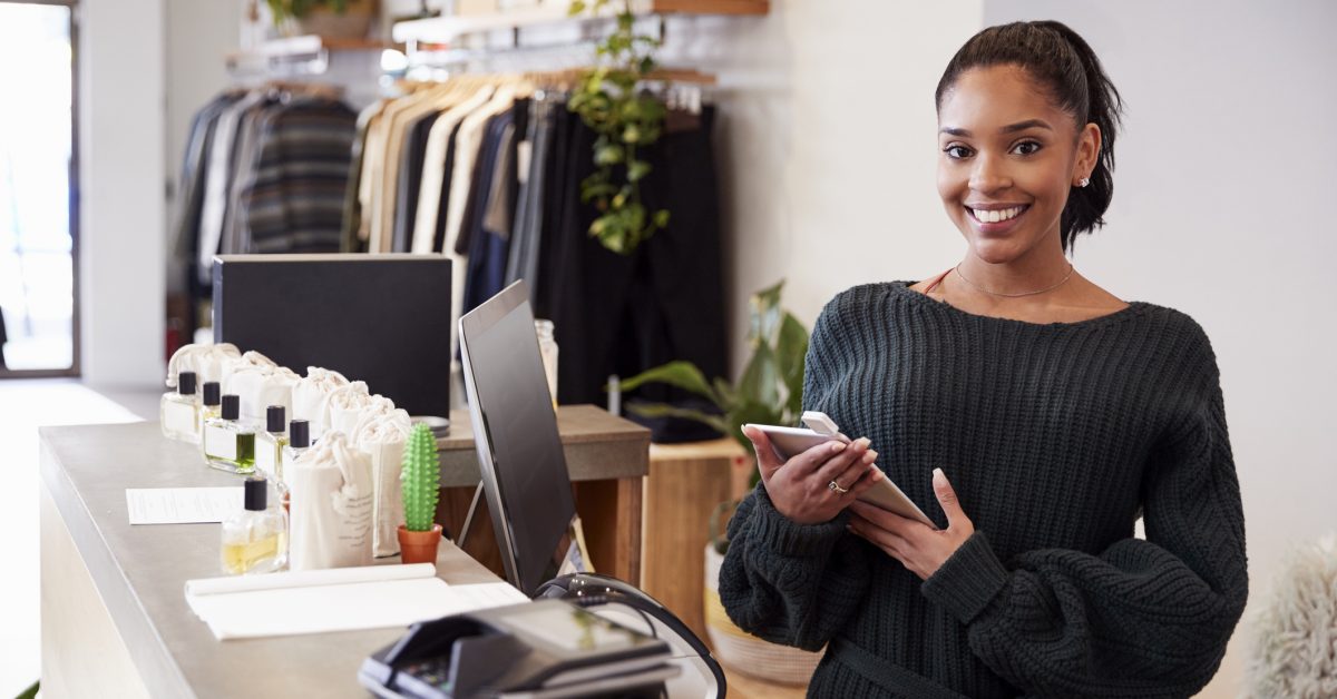 Female assistant smiling from the counter in clothing store